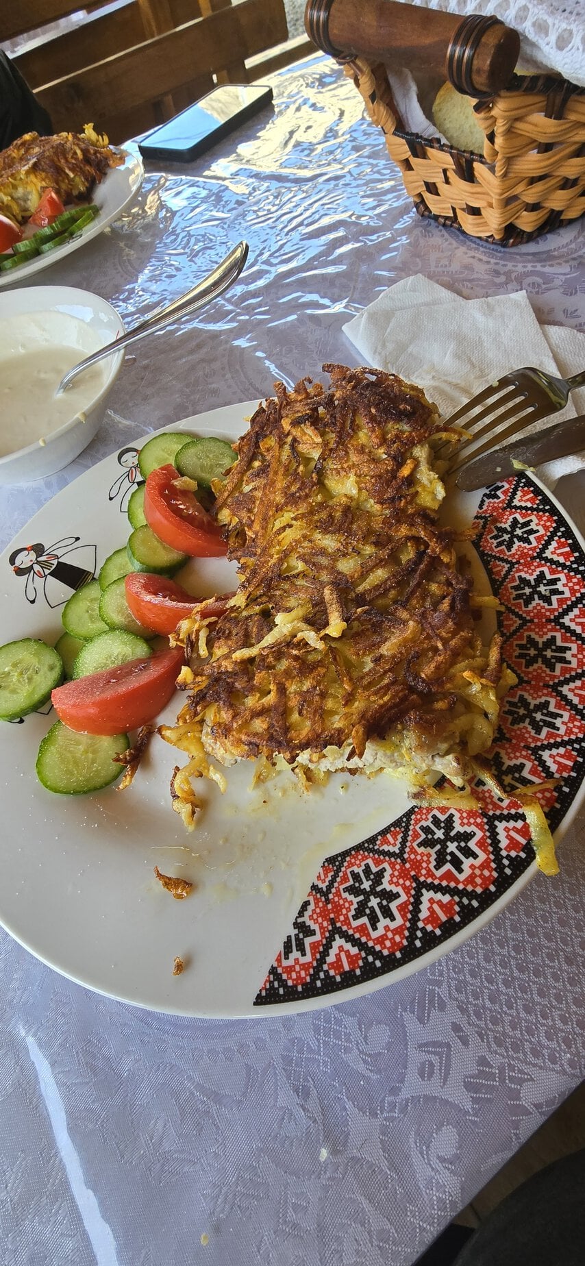 Ostropel de porc cu salată de legume proaspete și sos de iaurt, servit pe o farfurie decorativă trad.