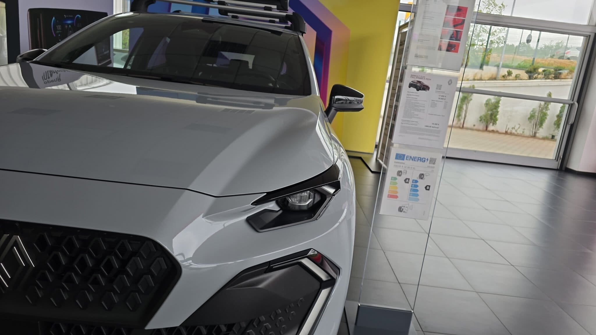 Mașină electrică albă expusă într-un showroom modern.