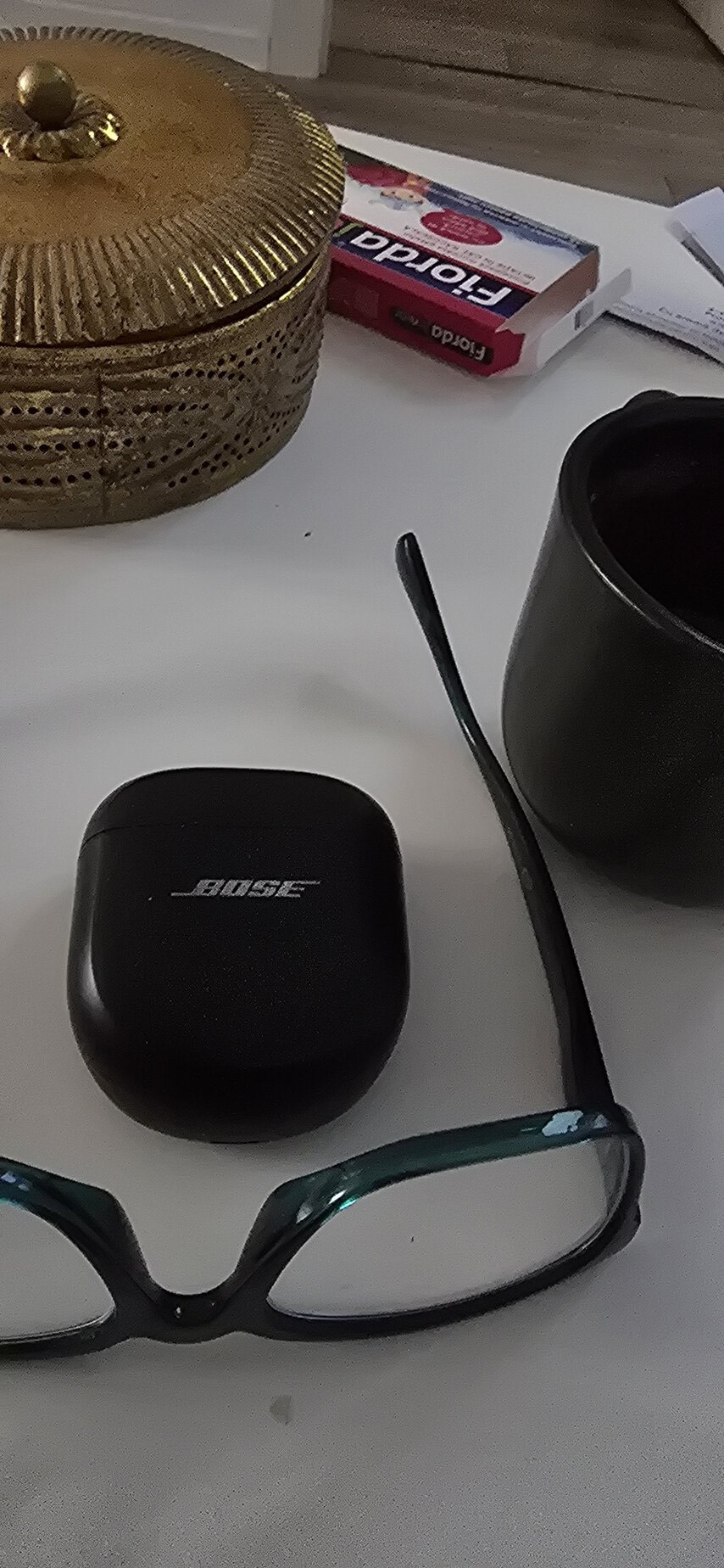 Căști wireless Bose și ochelari de vedere pe masă.