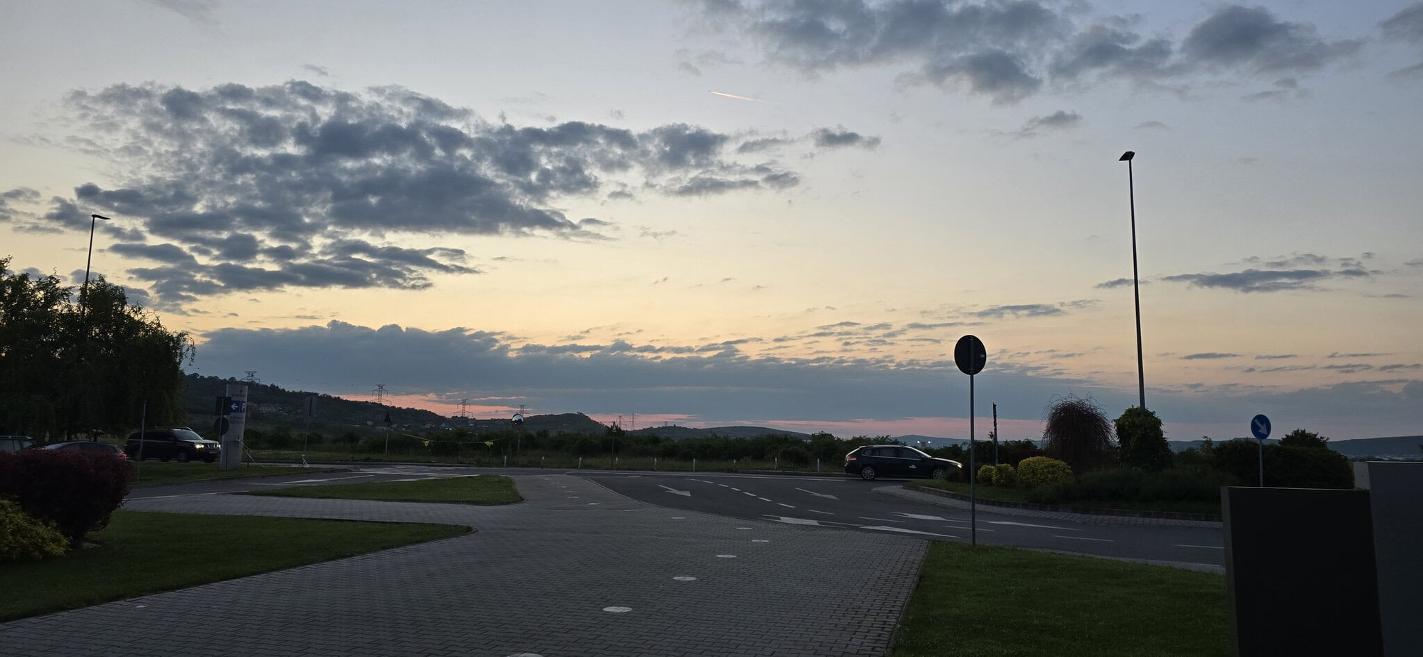 Cer senin cu nori în amurg, peste parc și drumuri pustii.